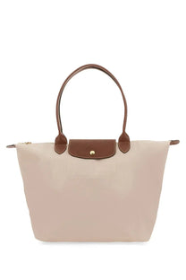 Beige longchamp le pliage large tote bag with brown leather handles and matching flap closure for women
