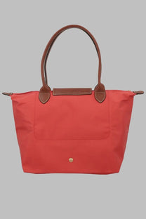 Vibrant coral-red Longchamp Le Pliage tote bag with brown leather handles and trim for women