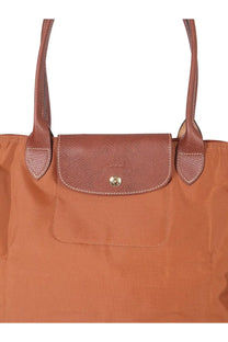 Longchamp women’s le pliage large tote bag in brown with leather trim textured flap and gold-tone button closure