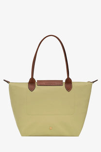A pale green Longchamp women’s le pliage nylon shoulder bag with brown leather handles and matching leather tab