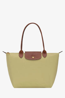 A sage green longchamp le pliage nylon tote bag with brown leather handles and matching flap closure for women