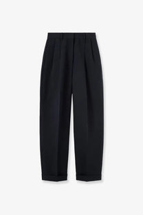 Black pleated tailored trousers with rolled cuffs shown from the back featuring a linen and cotton blend