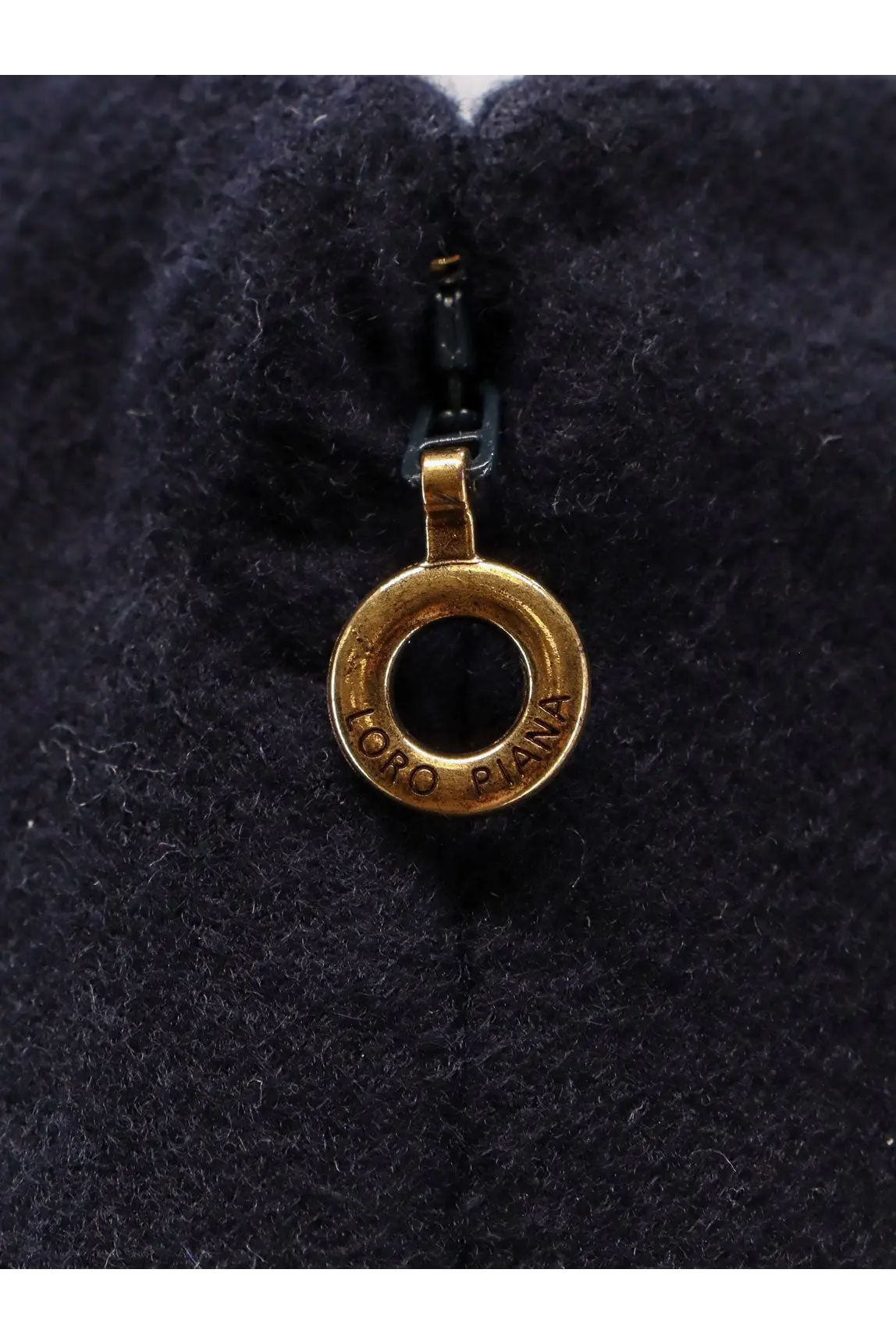 Gold-colored circular zipper pull engraved with loro piana on dark navy fabric of loro piana womens vivian cashmere skirt blue