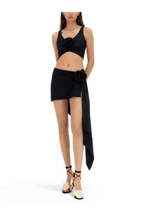 Black satin crop top with three-dimensional rose embellishment paired with magda butrym asymmetrical skirt swim black