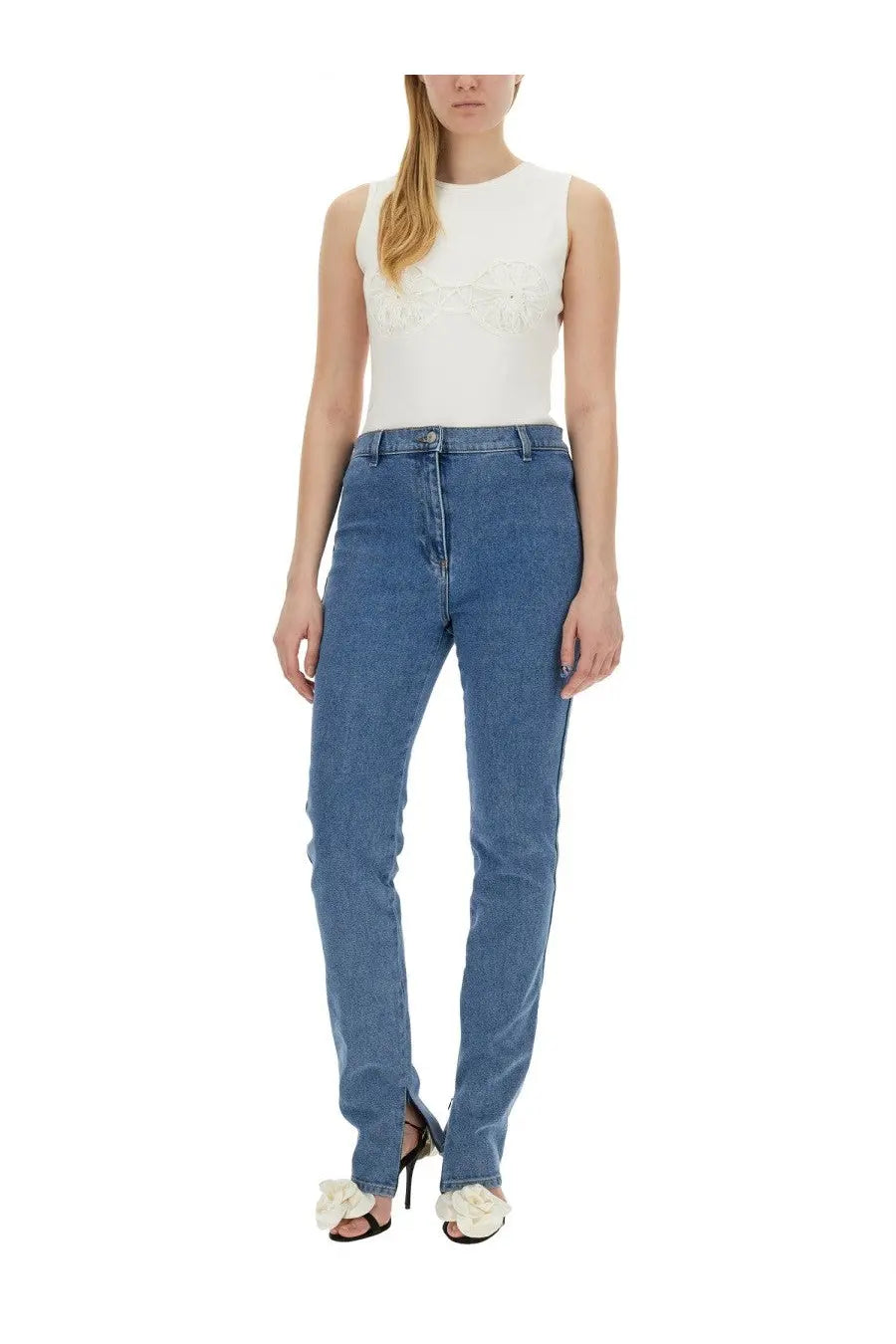 High-waisted medium blue denim jeans with straight-leg cut and front zipper fly paired with magda butrym white crochet bra shirt