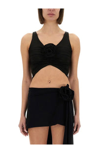 Magda Butrym women’s black satin crop top with ruched fabric and rose embellishment paired with matching skirt