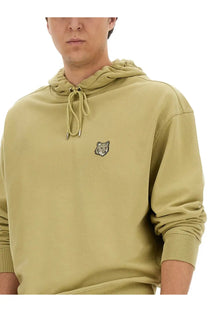 Maison Kitsuné men’s oversized olive green hooded sweatshirt with embroidered fox patch and matching drawstrings