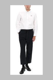 White button-down shirt with small red fox logo on left chest paired with maison kitsuné black technical fabric belt pants