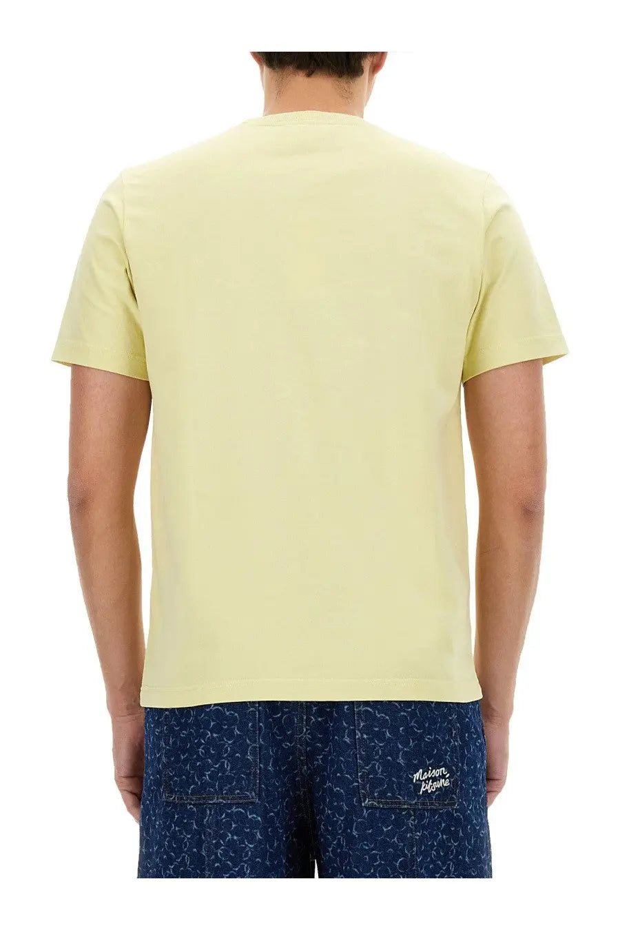 Back view of maison kitsuné men’s beige short-sleeved t-shirt with crew neck and subtle branding on lower back