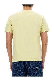 Back view of maison kitsuné men’s beige short-sleeved t-shirt with crew neck and subtle branding on lower back