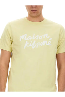 Maison kitsuné men’s beige short-sleeved t-shirt with white cursive logo across the chest in pale yellow fabric