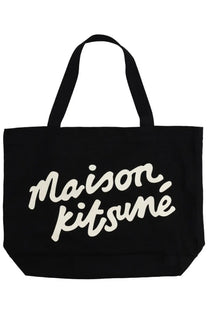 Black canvas Maison Kitsuné women’s tote bag with white cursive branding and sturdy shoulder straps