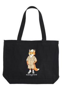 Maison Kitsuné women’s black canvas tote bag featuring a cartoon fox in beige safari attire and white cap