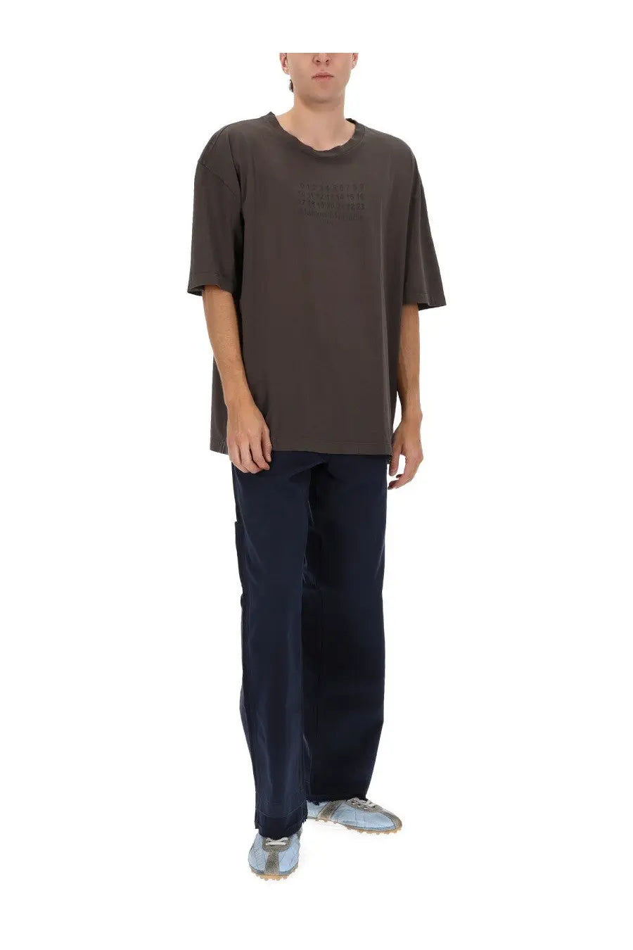 Maison Margiela men’s five pockets jeans in blue paired with a dark gray oversized short-sleeved t-shirt with faded logo