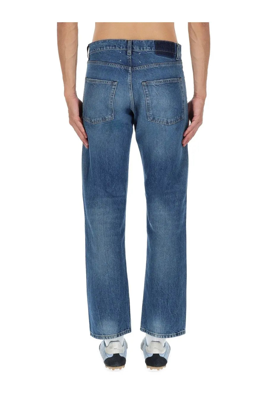 Back side of Maison Margiela men’s blue denim jeans with straight-leg cut subtle fading classic back pockets and dark waistband