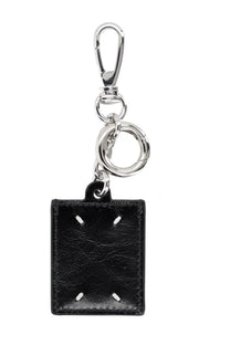 Maison Margiela men’s black leather keychain with silver clasp and ring featuring minimalist rectangular design and white stitching