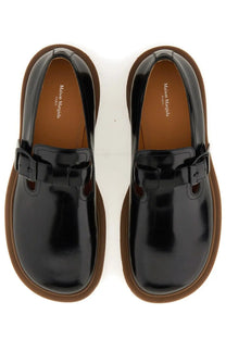 Maison Margiela men’s leather monk black patent slip-on shoes with buckle strap and brown rubber soles