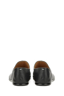 Maison Margiela men’s black leather tabi mules with subtle textured finish and tan lining shown from the back side