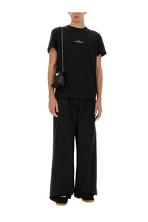 Black leather mini bag with silver chain strap and white logo detail paired with maison margiela black cotton shirt
