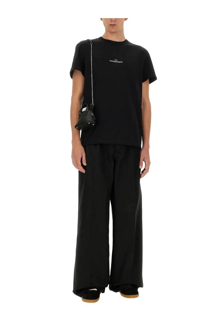 Black leather mini bag with silver chain strap and white logo detail paired with maison margiela multicolor cotton shirt