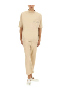 Beige high neck short-sleeved t-shirt with distressed details and marsèlla logo on chest pocket paired with white maison margiela cotton pants