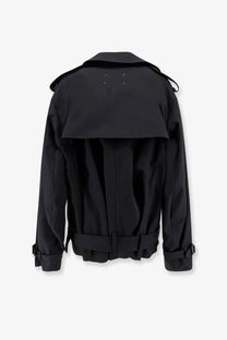 Back view of maison margiela women’s black cotton blend mini trench coat with structured collar belted waist and white stitching