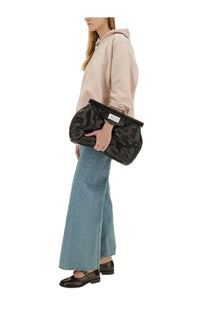 Black quilted cotton clutch with minimalist white label on flap shown with Maison Margiela blue sweatshirt
