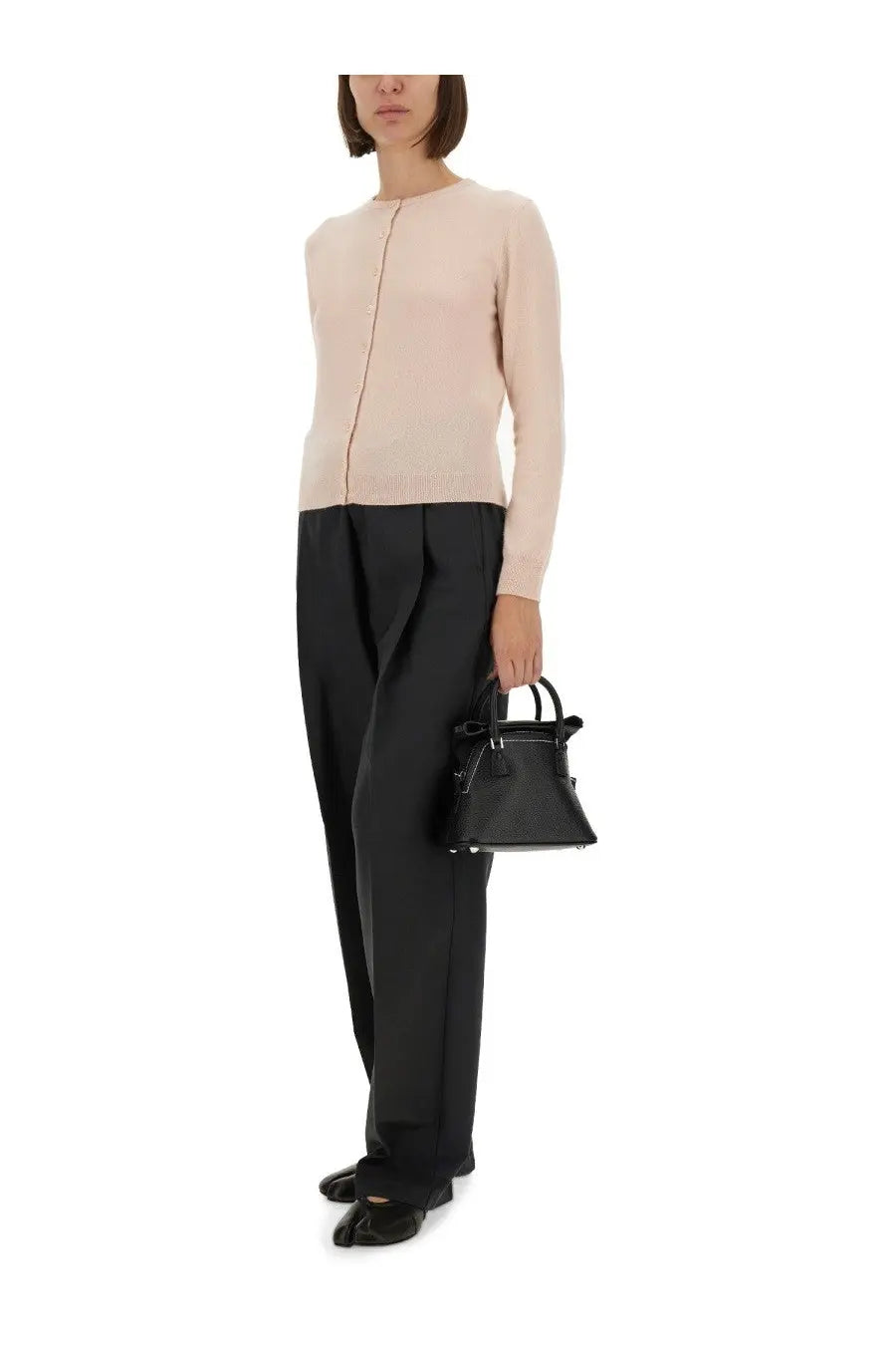 Black leather mini handbag with structured triangular shape and top handles paired with maison margiela blue cardigan