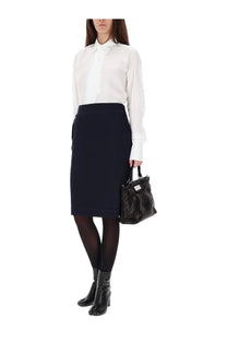Black leather handbag with structured shape and top handles paired with maison margiela womens blue midi skirt