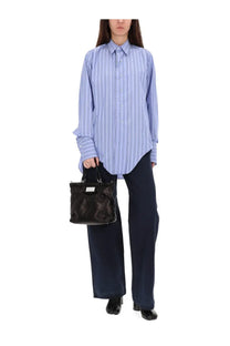 Black leather handbag with rectangular shape and silver-tone hardware paired with maison margiela womens blue herringbone pants
