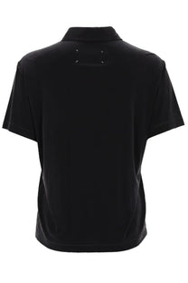 Back view of maison margiela women’s black cupro polo shirt with short sleeves classic collar and white stitching detail