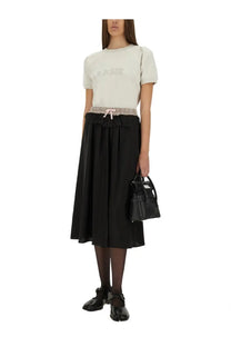 Black structured leather mini handbag with top handles and front flap closure paired with maison margiela white sweatshirt