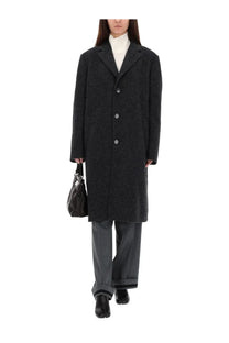 Black textured wool overcoat with silver buttons paired with maison margiela women’s tailored grey pants