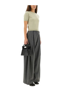 Black leather mini handbag with top handles and front flap closure paired with Maison Margiela green wool crew neck shirt
