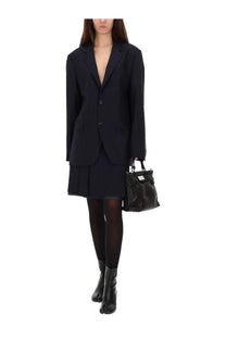 Maison Margiela women’s black wool blazer with deep v-neck and three-button front paired with matching skirt and tights