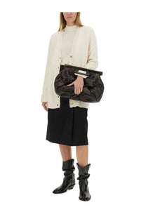 Black quilted clutch with a structured top flap and gold tone hardware paired with maison margiela wool jersey white