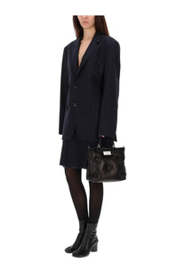 Black quilted leather handbag with rectangular shape and top handles paired with maison margiela womens blue wool midi skirt