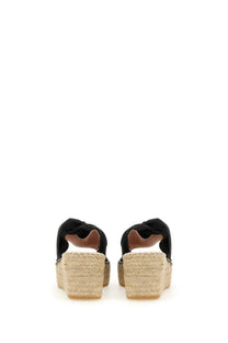 Manebi women’s knot sandal black with woven espadrille wedge heel and knotted strap detail on black fabric