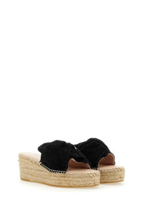 Manebi women’s knot sandal black suede slide with woven espadrille wedge heel shown from the back side
