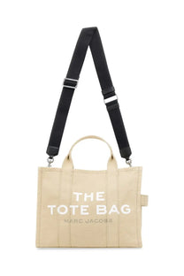 Marc Jacobs women’s beige canvas medium tote bag with black adjustable strap and bold white the tote bag lettering