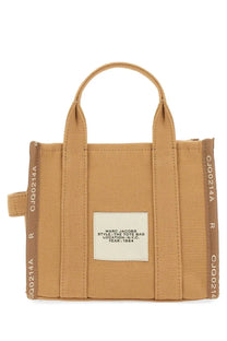 Tan canvas marc jacobs tote bag with brown ribbed side panels and a white style label from new york city