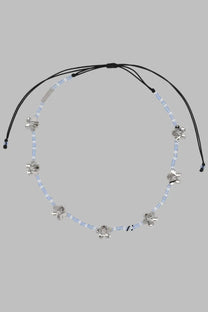 Marc Jacobs women’s collana daisy silver necklace with black cord, light blue beads, and silver flower charms