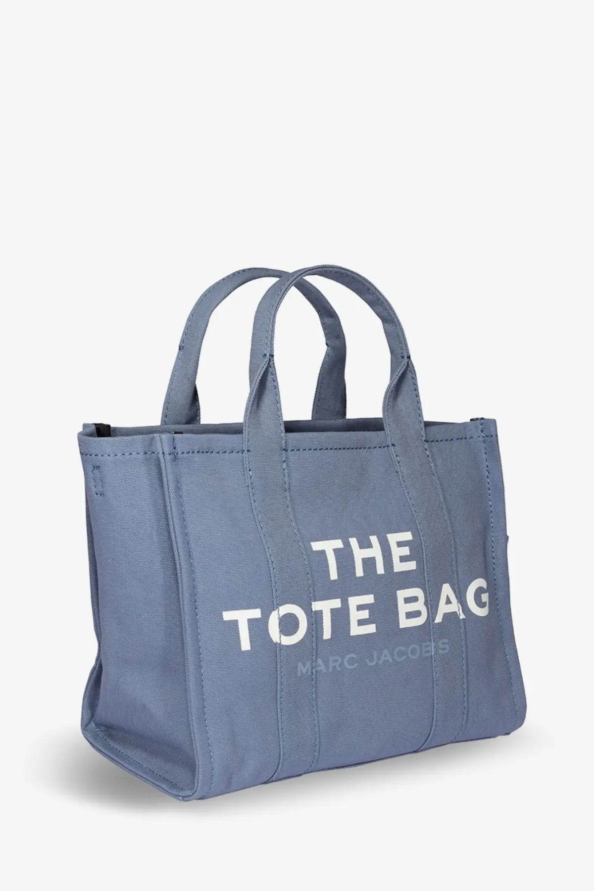 A light blue canvas Marc Jacobs medium tote bag with white lettering and a denim crossbody strap