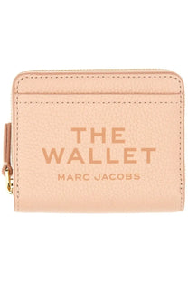 A blush pink textured leather wallet with the wallet and marc jacobs embossed from marc jacobs women’s portafoglio collection
