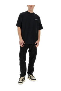 Black oversized t-shirt with a small white logo on the left chest worn with marcelo burlon county of milan men’s cargo pants