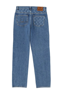 Back side of marine serre men’s blue waxed denim jeans with subtle crescent moon pattern and brown leather patch