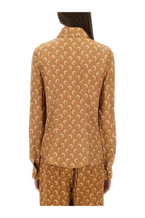 A woman wears a caramel-colored marine serre women’s moon satin shirt with cream crescent moon pattern and long sleeves