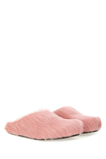 Pink faux fur slip-on mules with soft plush texture and dark rubber soles styled as Marni men’s Fussbett sabot blue