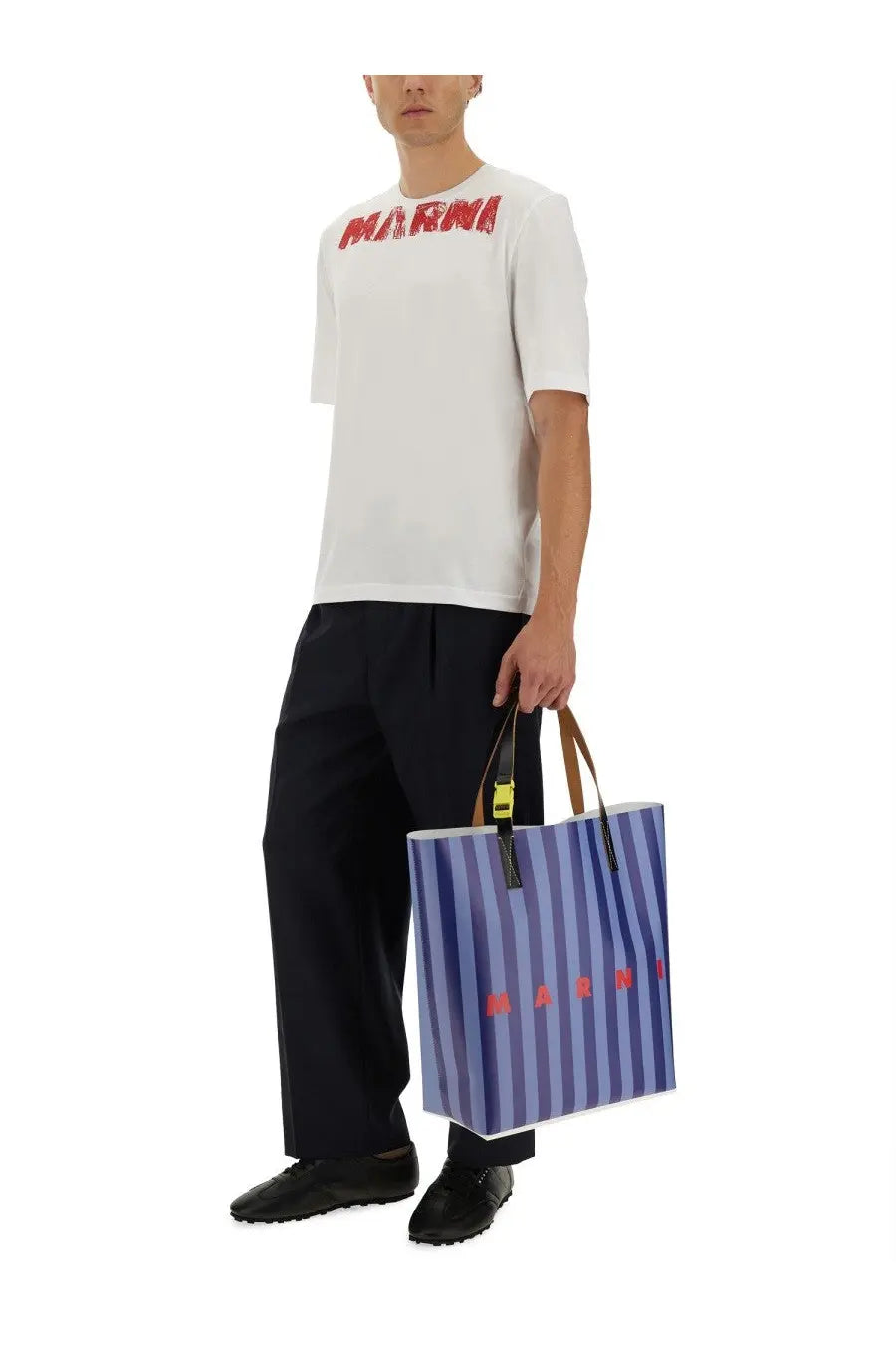 Blue and white striped marni tote bag with brown handles and yellow hardware paired with marni men’s blue wool pants