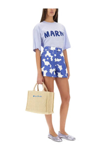 Beige woven tote bag with blue embroidered logo paired with Marni women’s multicolor cotton shorts